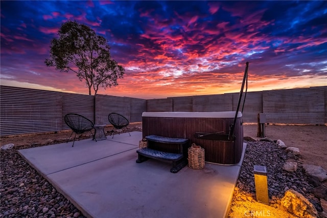 patio terrace at dusk with a hot tub