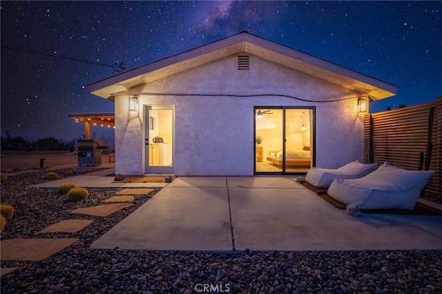 back house at night with a patio area