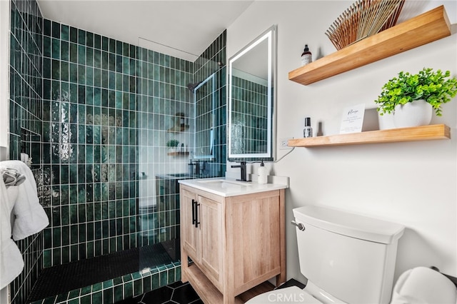 bathroom featuring vanity, tiled shower, and toilet