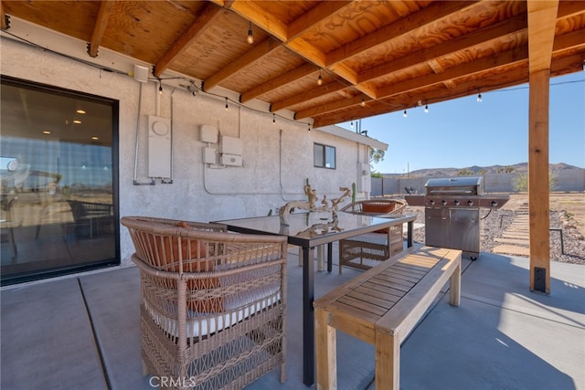 view of patio / terrace with a mountain view and a grill