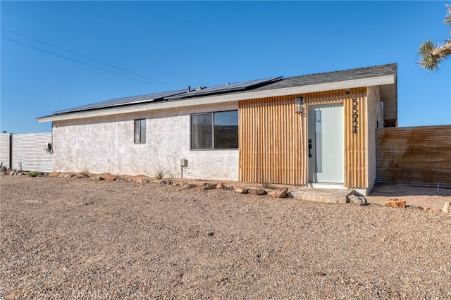 back of house featuring solar panels