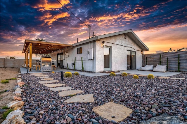 back house at dusk with a patio area