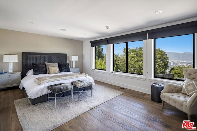 bedroom with a mountain view and dark hardwood / wood-style floors