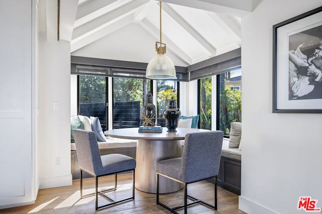 dining area featuring lofted ceiling with beams and wood-type flooring