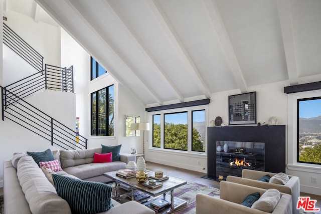 living room featuring beam ceiling, hardwood / wood-style flooring, high vaulted ceiling, and plenty of natural light