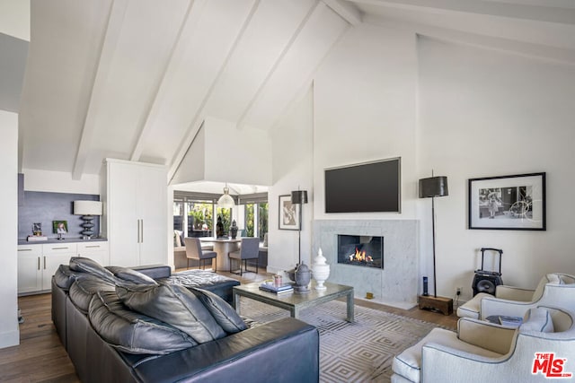 living room featuring dark wood-type flooring, beam ceiling, high vaulted ceiling, and a high end fireplace