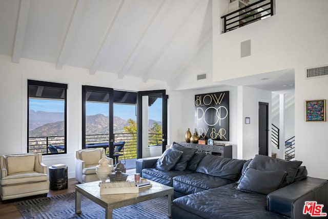 living room with a mountain view, high vaulted ceiling, wood-type flooring, and beamed ceiling