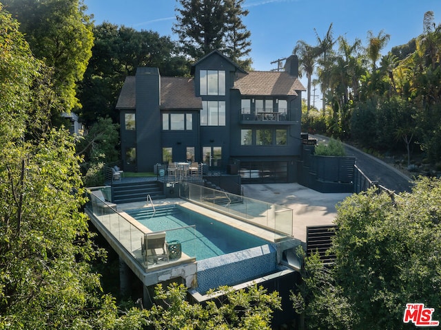 rear view of property with a balcony and a patio area