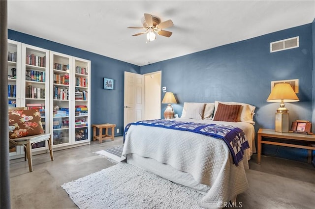 bedroom with ceiling fan and concrete flooring