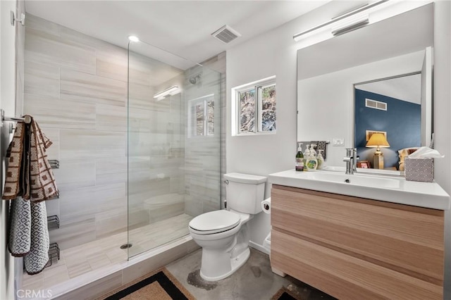 bathroom featuring vanity, toilet, and a shower with shower door