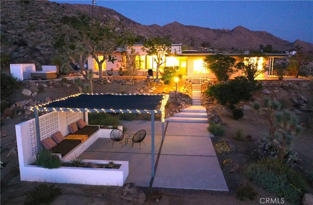 view of front of home with a mountain view and a patio area