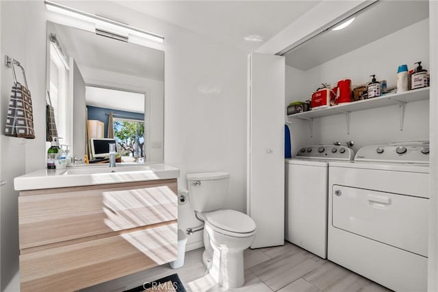 bathroom with vanity, toilet, and washer and clothes dryer