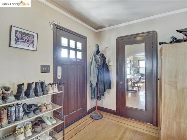 foyer with wood-type flooring and ornamental molding