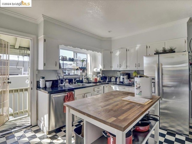 kitchen featuring sink, crown molding, appliances with stainless steel finishes, and white cabinetry