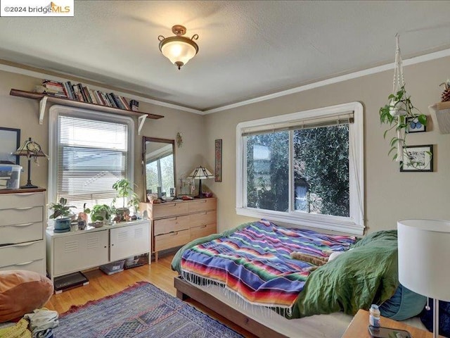 bedroom with crown molding and hardwood / wood-style flooring