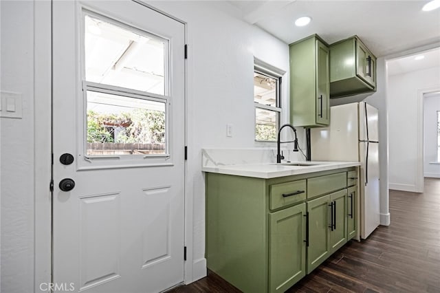 kitchen featuring sink, green cabinetry, dark hardwood / wood-style floors, and a healthy amount of sunlight