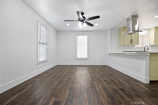 unfurnished living room with ceiling fan and dark hardwood / wood-style flooring