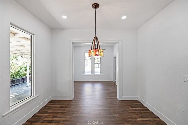 unfurnished dining area featuring a wealth of natural light and dark hardwood / wood-style floors