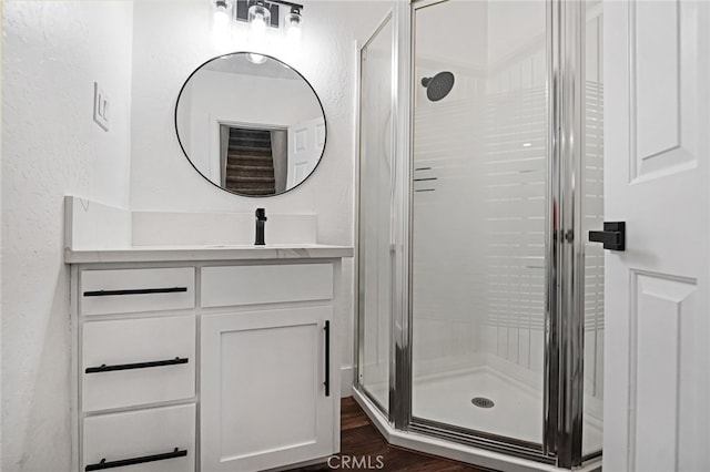 bathroom with a shower with door, vanity, and wood-type flooring