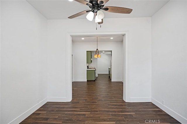 spare room featuring dark wood-type flooring and ceiling fan