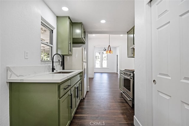 kitchen with high end range, sink, and green cabinetry