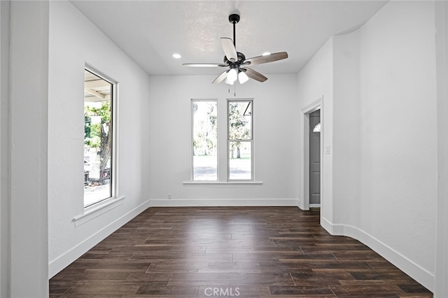 unfurnished room with ceiling fan, a wealth of natural light, and dark hardwood / wood-style flooring