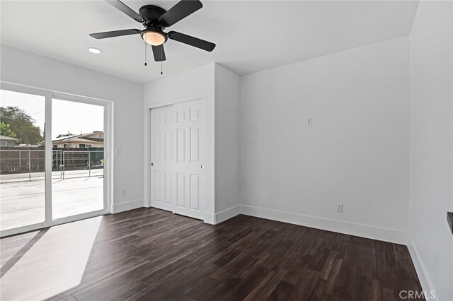 unfurnished bedroom with dark hardwood / wood-style flooring, access to outside, a closet, and ceiling fan