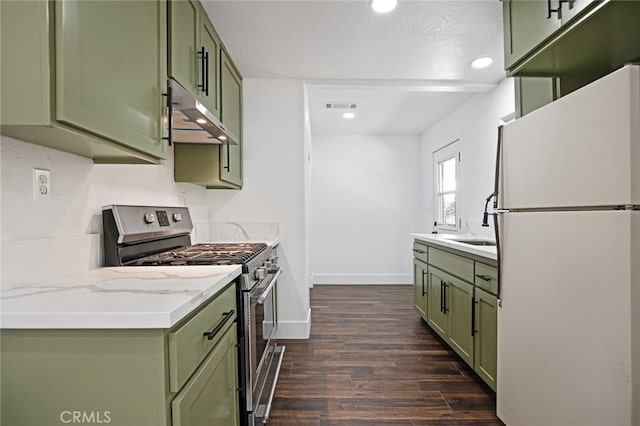 kitchen featuring white fridge, green cabinets, dark wood-type flooring, and stainless steel range with gas stovetop