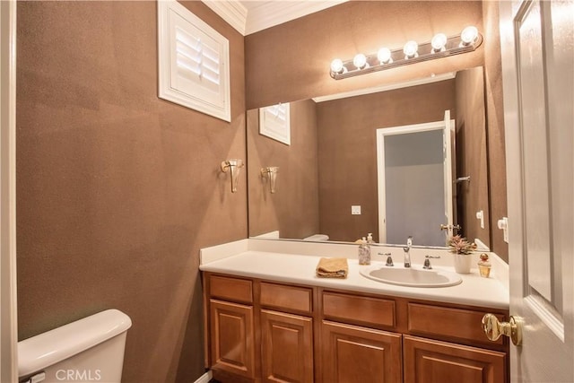 bathroom featuring vanity, toilet, and ornamental molding