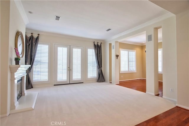 unfurnished living room with wood-type flooring and ornamental molding