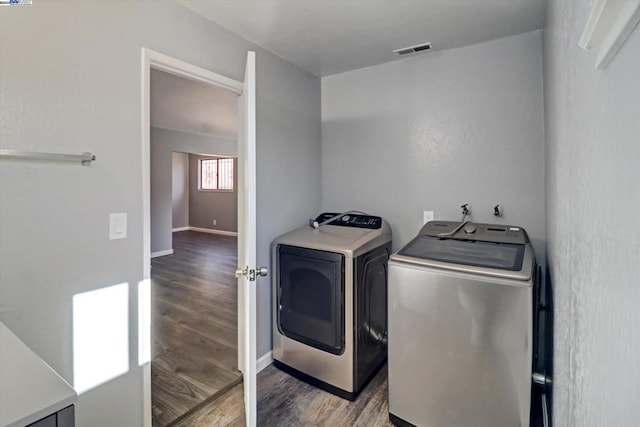 washroom featuring hardwood / wood-style flooring and washer and clothes dryer