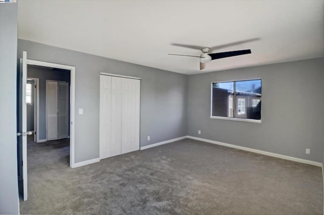 unfurnished bedroom with dark carpet and ceiling fan