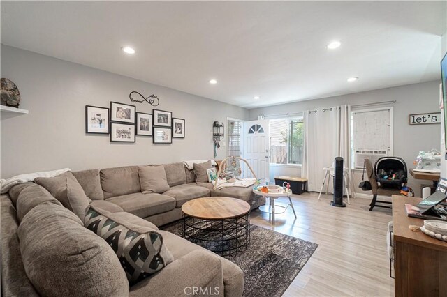 living room with cooling unit and light hardwood / wood-style flooring