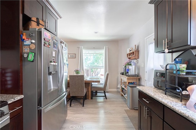 kitchen with dark brown cabinets, light stone countertops, and stainless steel refrigerator with ice dispenser