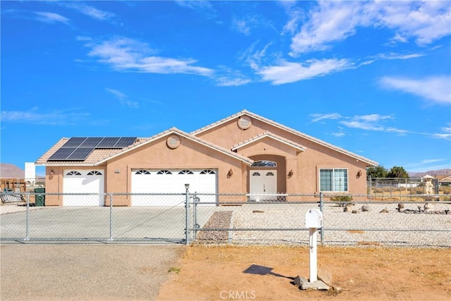 view of front facade featuring solar panels and a garage