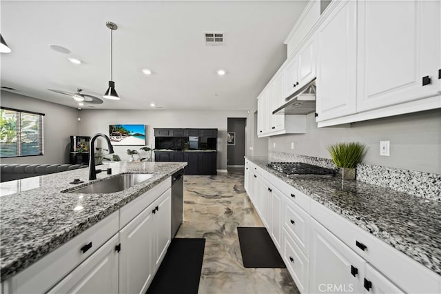 kitchen with appliances with stainless steel finishes, sink, white cabinets, and hanging light fixtures