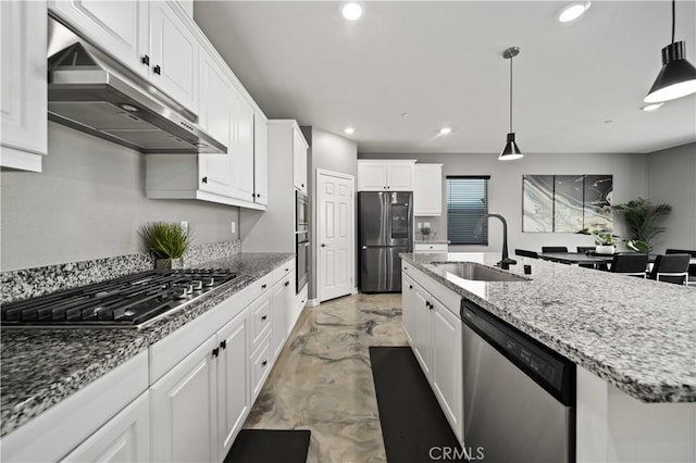 kitchen with sink, appliances with stainless steel finishes, white cabinets, and an island with sink