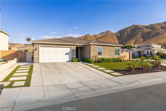 view of front facade featuring a front yard, a garage, and a mountain view