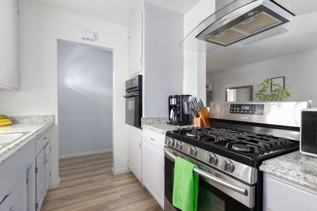 kitchen with ventilation hood, light hardwood / wood-style flooring, white cabinets, stainless steel gas stove, and oven