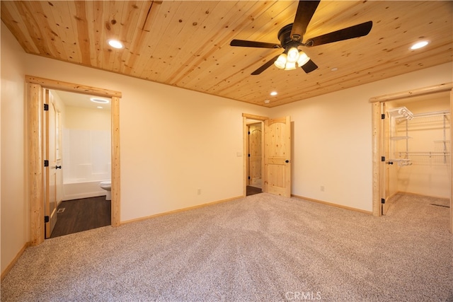 unfurnished bedroom featuring ensuite bathroom, carpet flooring, a closet, ceiling fan, and wooden ceiling