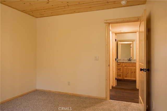 spare room featuring wood ceiling, sink, and light wood-type flooring