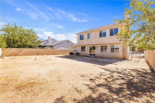 back of property with a fenced backyard and stucco siding