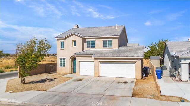 traditional-style home featuring fence, a tiled roof, stucco siding, driveway, and an attached garage
