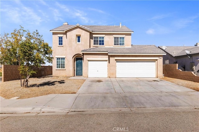 view of front of home with fence, a tiled roof, concrete driveway, stucco siding, and a garage