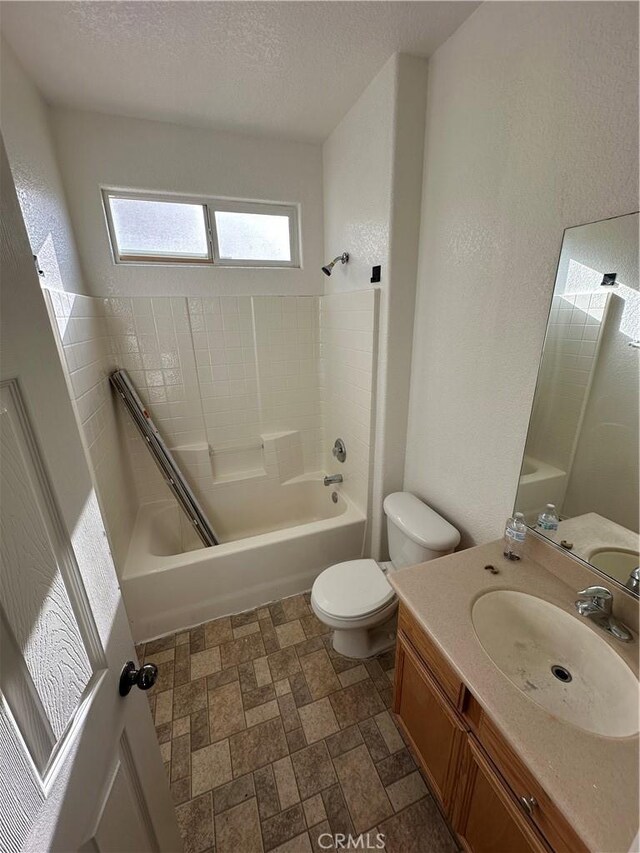 full bath with toilet, shower / bathing tub combination, a textured wall, a textured ceiling, and vanity