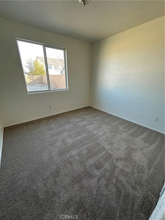 carpeted empty room featuring a textured ceiling