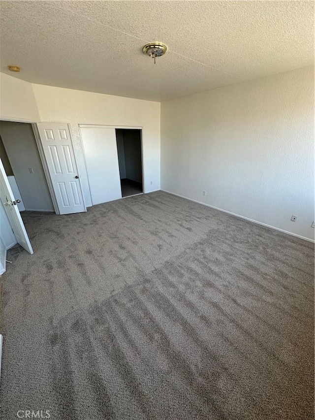 unfurnished bedroom featuring a closet, a textured ceiling, and carpet floors