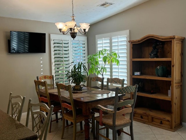 dining area with a notable chandelier, light tile patterned floors, and lofted ceiling