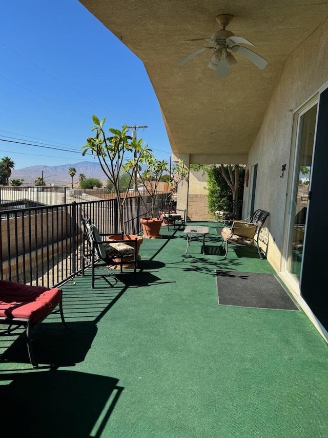 view of patio with ceiling fan and a mountain view