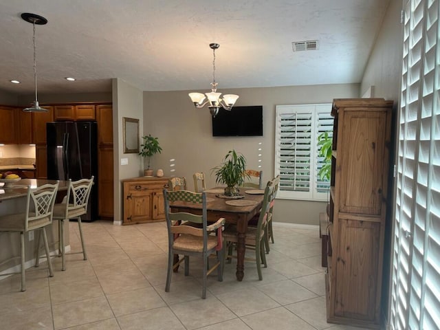 tiled dining space with a notable chandelier